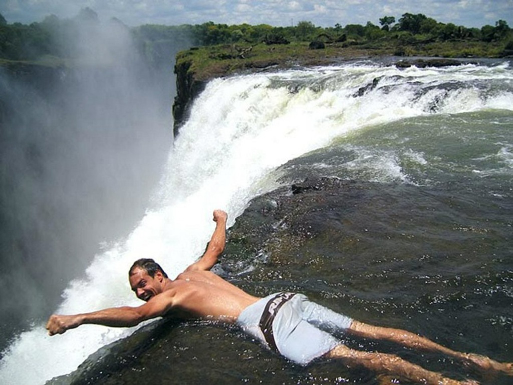 Водопад Виктория в Зимбабве. "Купель Дьявола" - естественный горный водоем на высоте в 120 метров, где вода относительно спокойна. С сентября по декабрь, когда уровень воды низок, в "Купели" можно плавать.